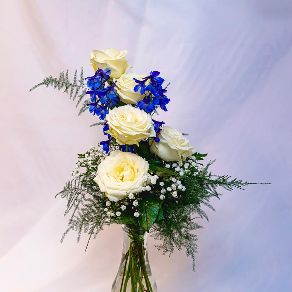 Sinisen ja valkoisen värisistä kukista koostuva kukkakimppu maljakossa